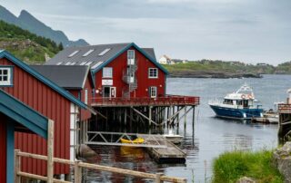 a group of red houses sitting next to a body of water