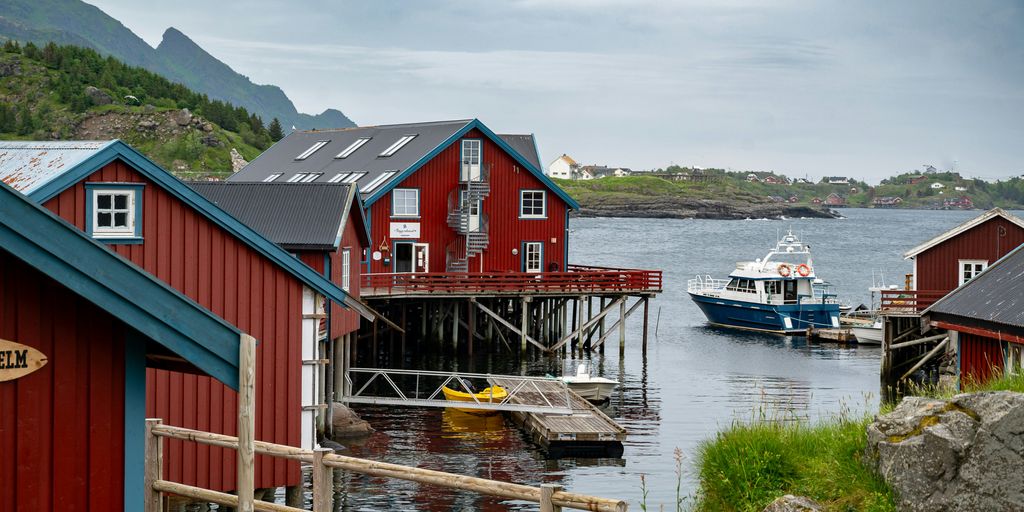 a group of red houses sitting next to a body of water