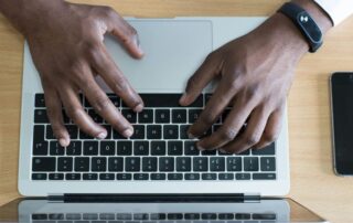 person's hand on MacBook near iPhone flat lay photography