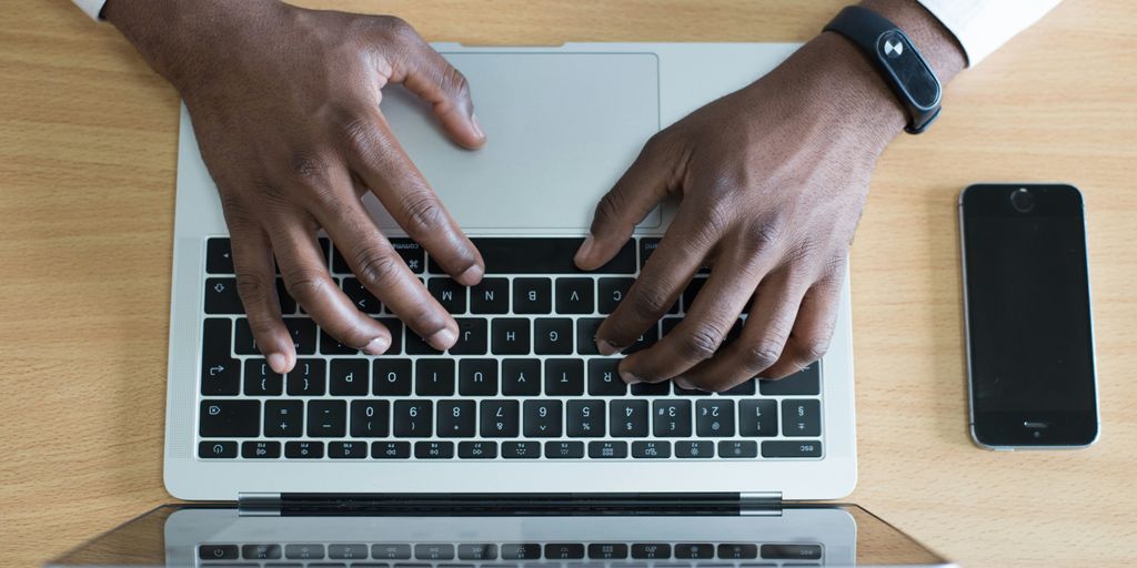 person's hand on MacBook near iPhone flat lay photography